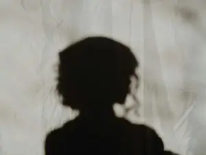 silhouette of person standing near white textile representing shadow work
