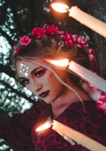 Divine feminine woman in red v neck shirt with red flower headdress