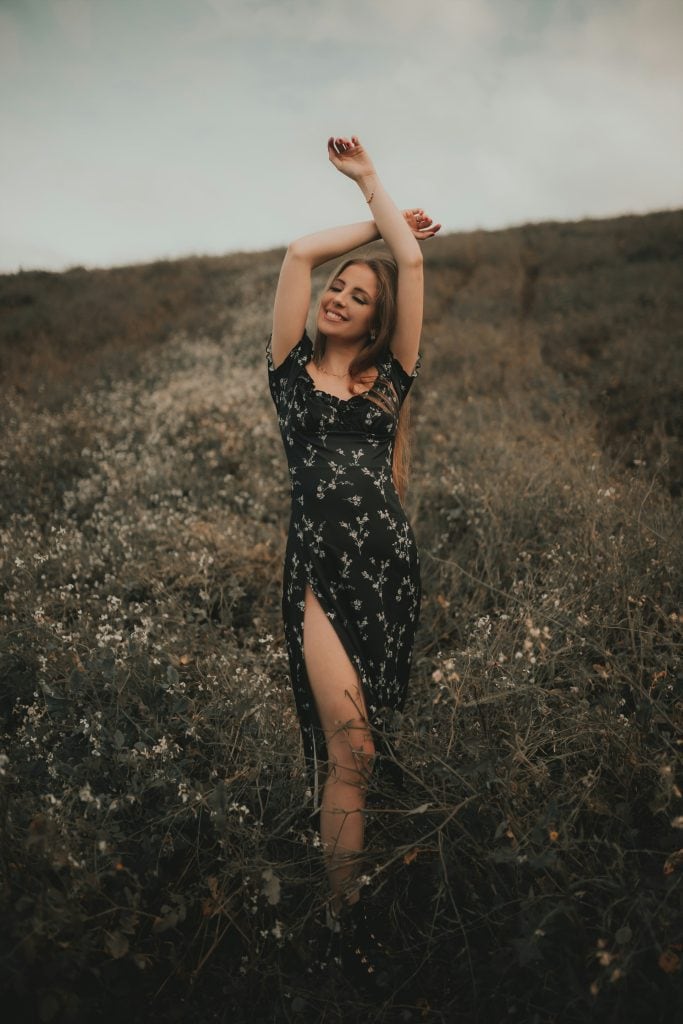 Confident woman with arms raised celebrating her spiritual power during Leo season