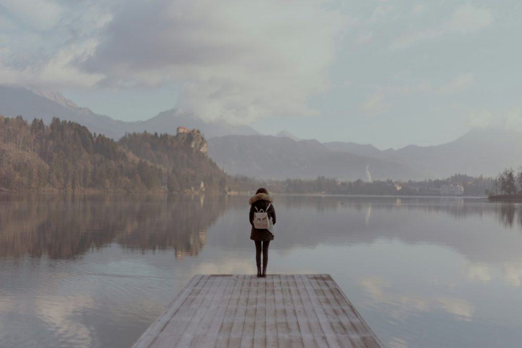 woman standing beside body of calm water to create back-to-school energy protection