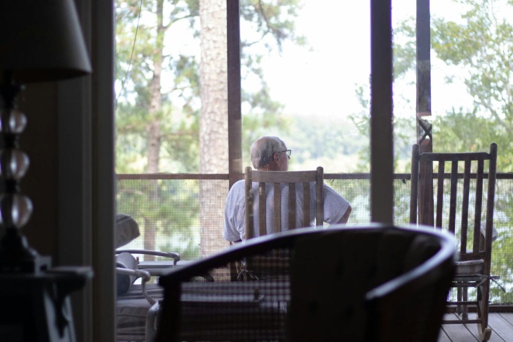 man sitting on chair near empty chair indoors representing a connection with ancestral wisdom