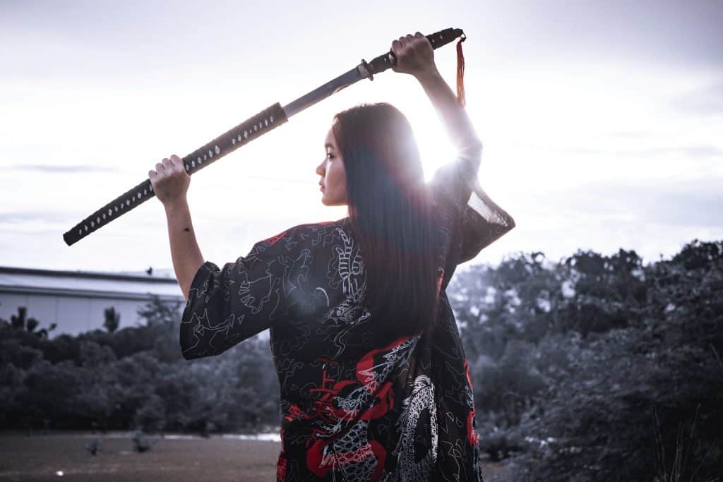 a woman holding a sword in her hands representing Aries energy during the hunter moon.